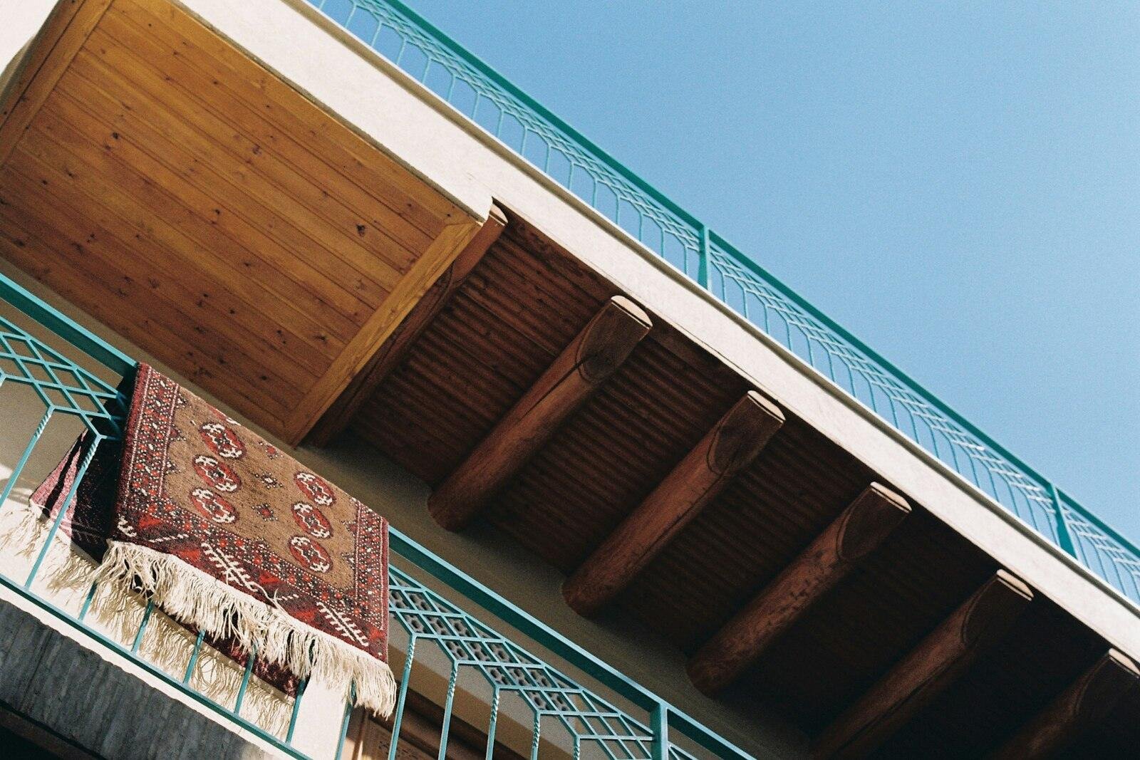 Apartman balkonunun korkuluğuna asılmış desenli halı